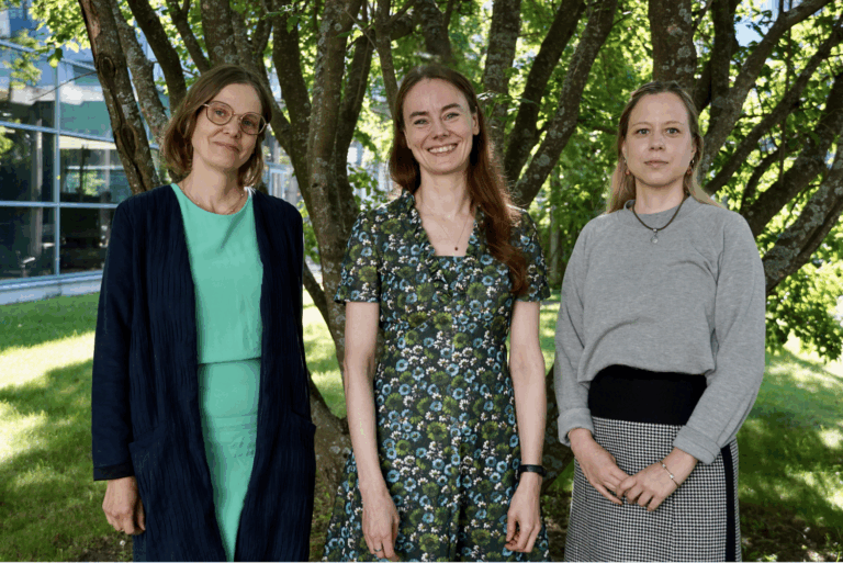Coordinator Mila Hyytinen, Director Mariike Kuijjer, and Scientific Coordinator Piia-Riitta Karhemo satnding in front of a tree