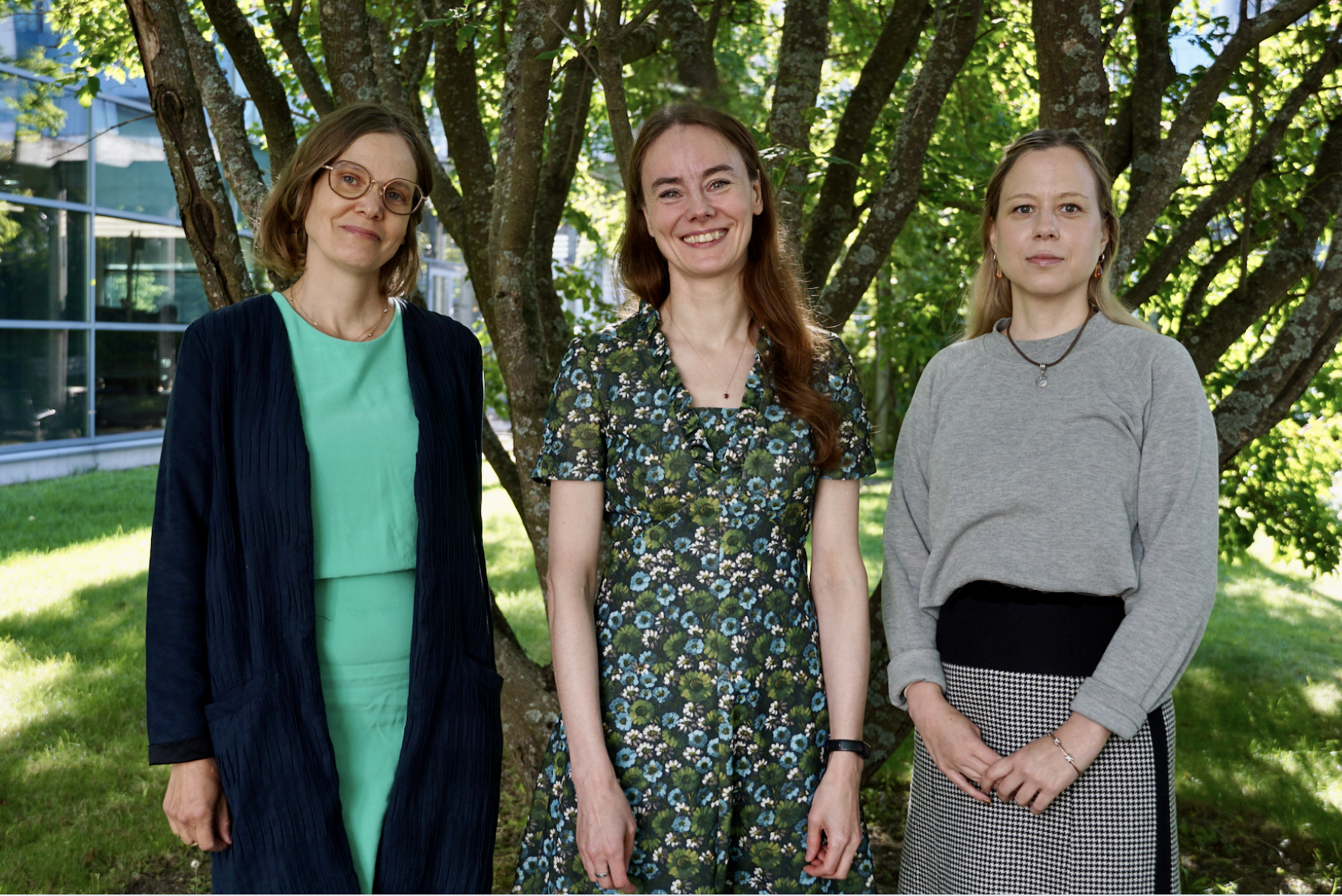 Coordinator Mila Hyytinen, Director Mariike Kuijjer, and Scientific Coordinator Piia-Riitta Karhemo satnding in front of a tree